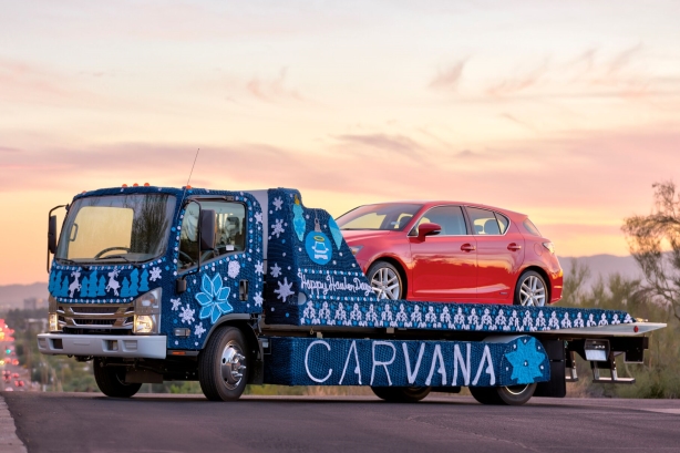 Driving brand awareness: Carvana dresses car hauler in giant ugly sweater