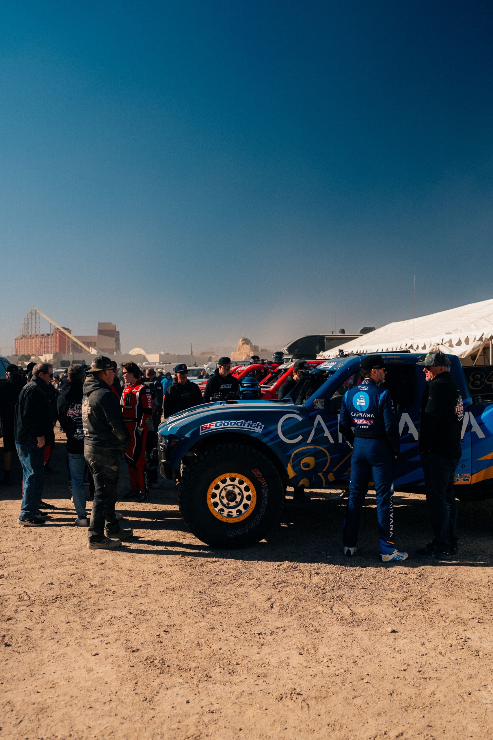 Jimmie Johnson wearing a Carvana and Terrible Herbst Motorsports race suit speaking in the pits at the BFGoodrich Mint 400 in Nevada.