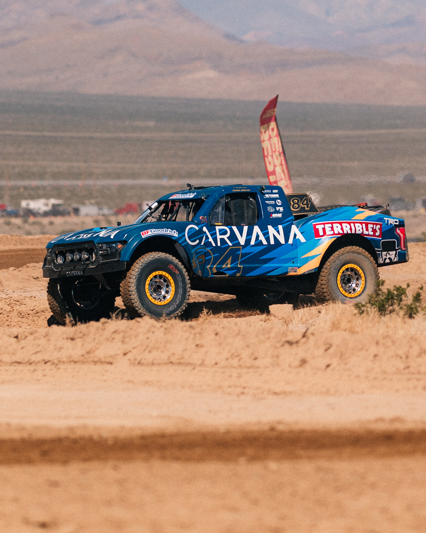 Carvana-sponsored No. 84 off-road race truck from Terrible Herbst Motorsports driving through the Nevada desert at the BFGoodrich Mint 400.