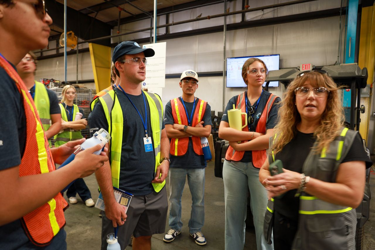 Carvana interns tour an Integrated Inspection and Reconditioning Center, wearing safety gear as they learn how teams, technology, and operations work together behind the scenes.